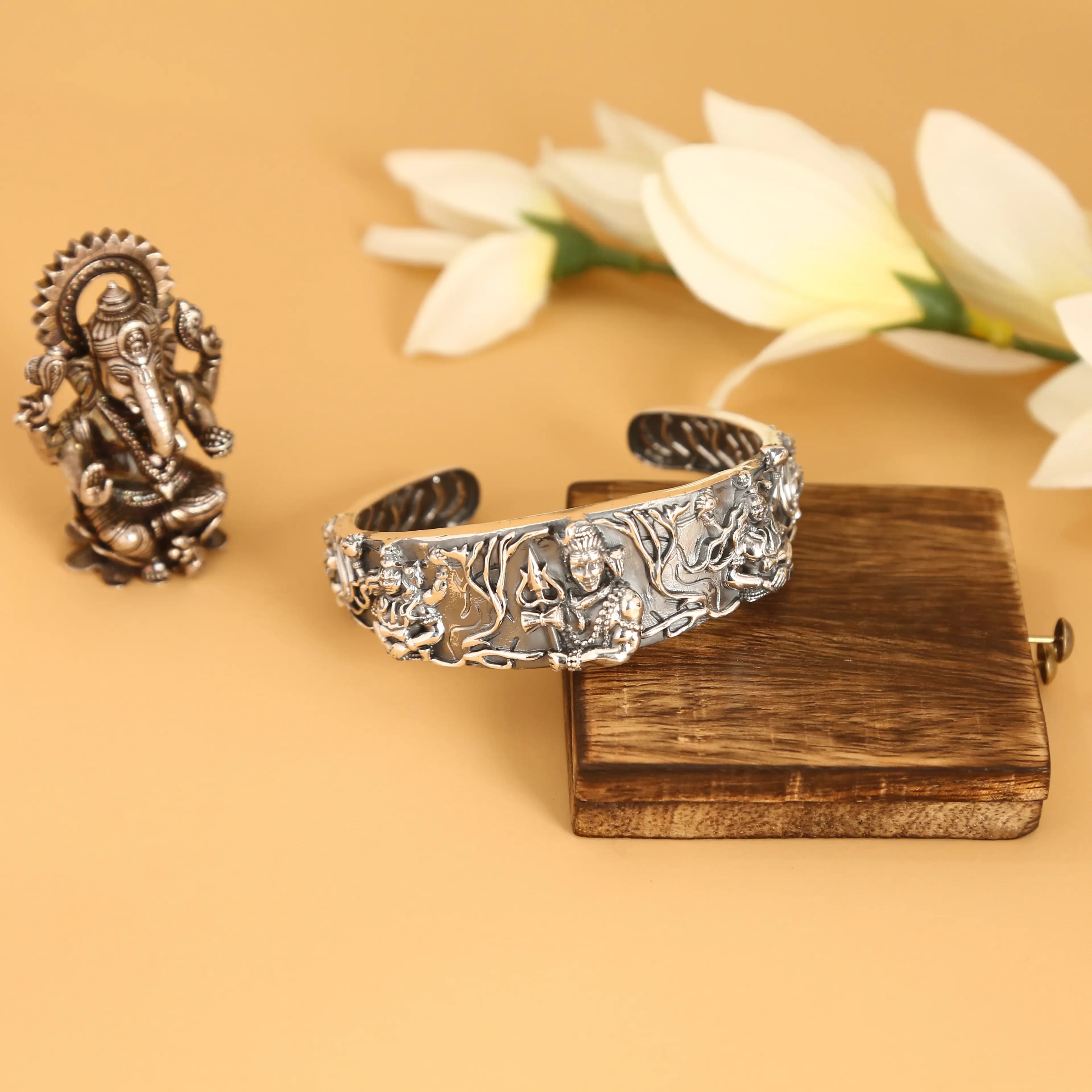 Intricately carved silver kada styled with a Ganesh idol — jewellery photography Udaipur