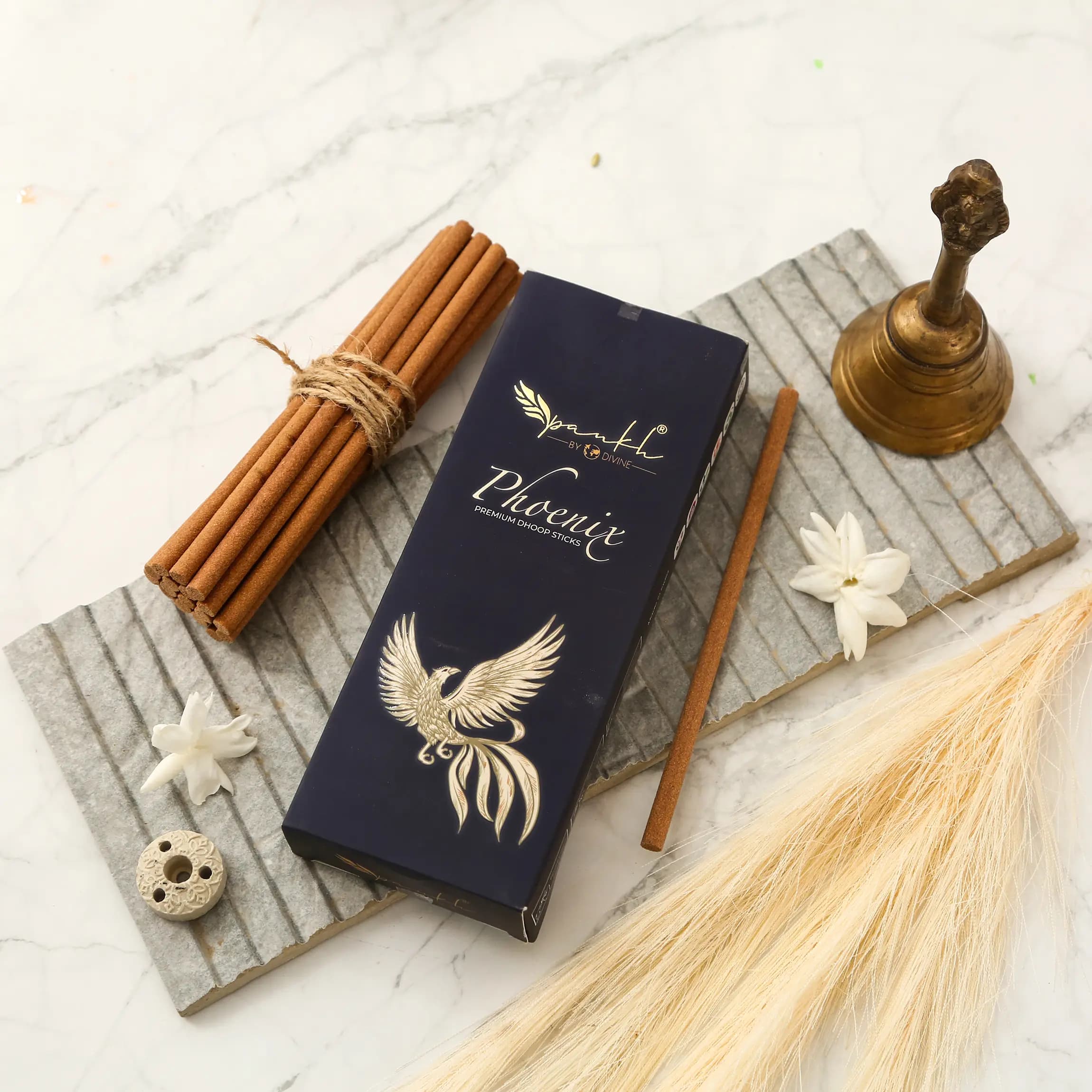 Pankh Phoenix incense sticks flat-lay with cinnamon and brass bell — product photography