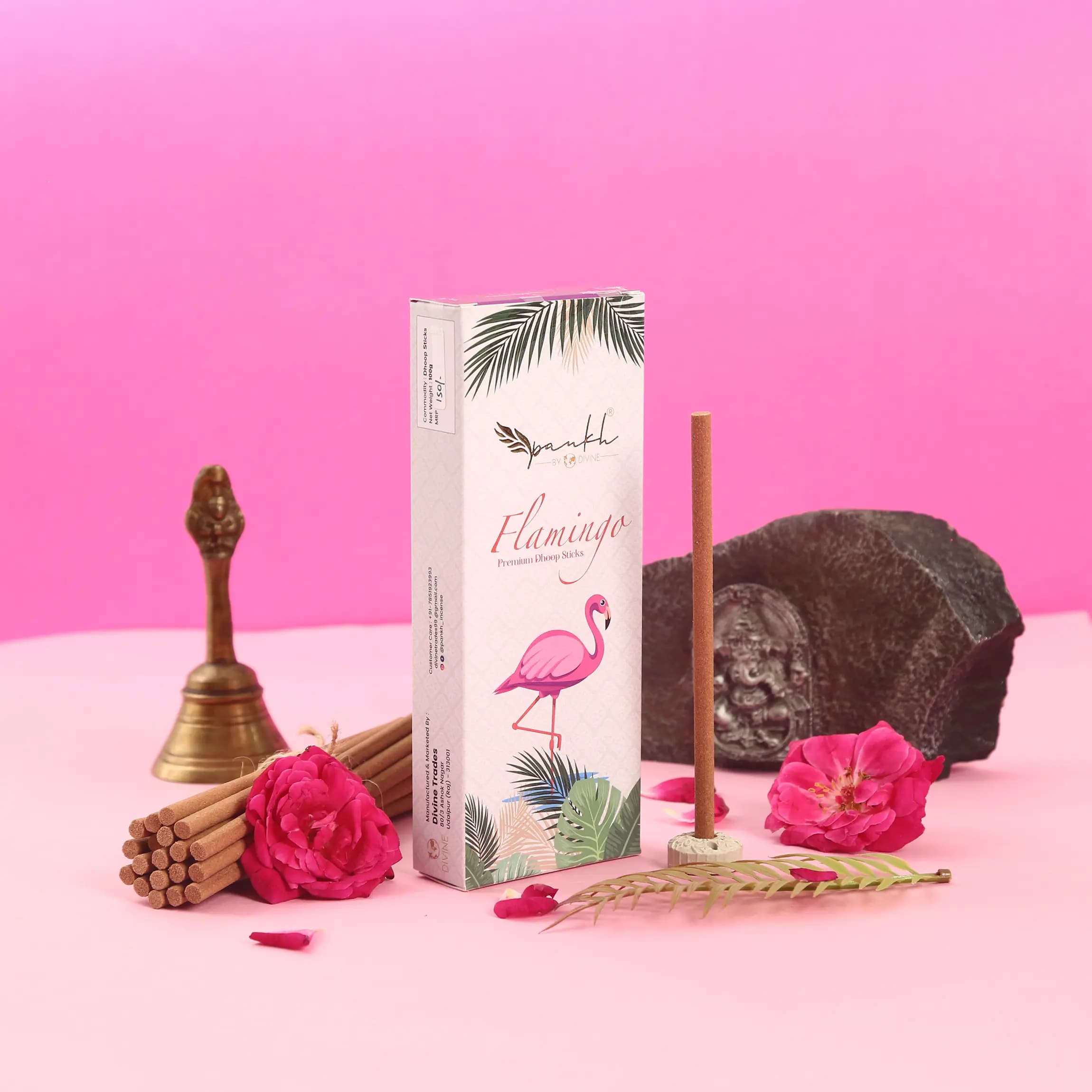 Pankh Flamingo incense box styled with brass bell and roses — lifestyle product photography